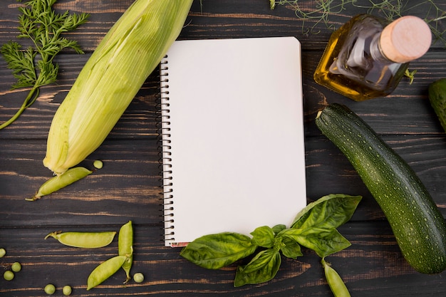 Top view arrangement of vegetables with empty notepad