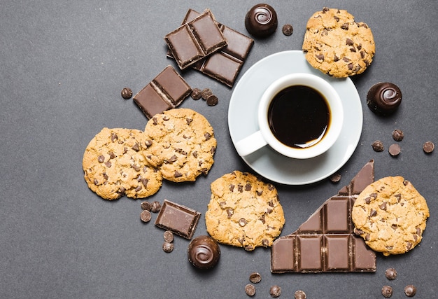 Top view arrangement with cookies, chocolate candies and coffee