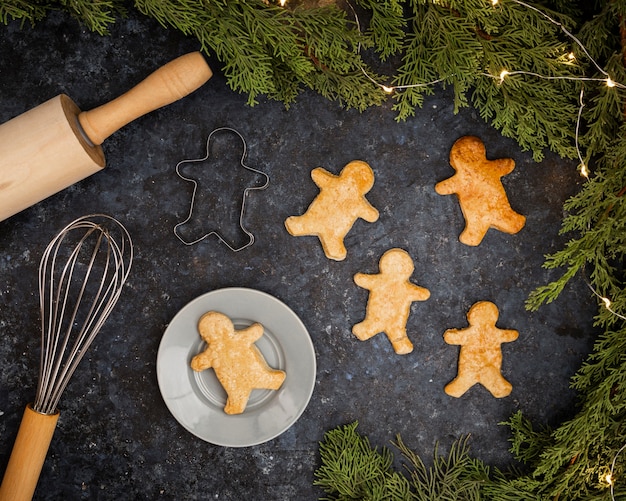 Free photo top view arrangement with gingerbread men on stucco background