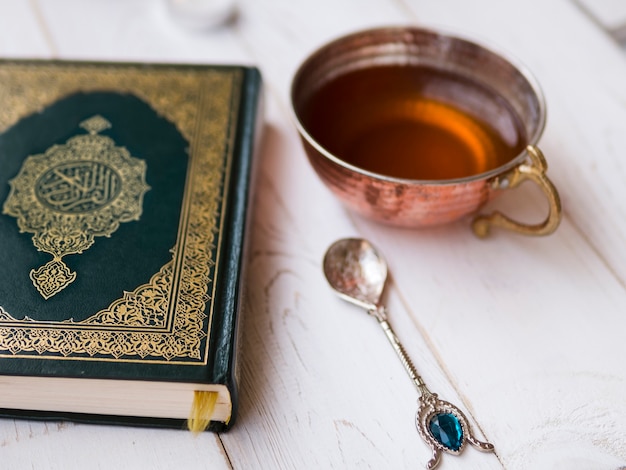 Free photo top view arrangement with quran, tea and spoon