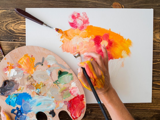 Top view of artist painting with brush and palette