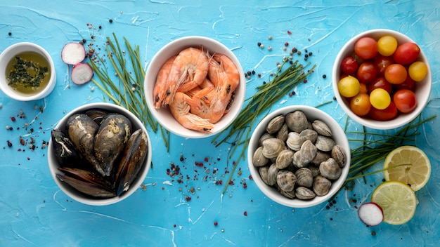 Free photo top view of assortment of bowls with tomatoes and clams