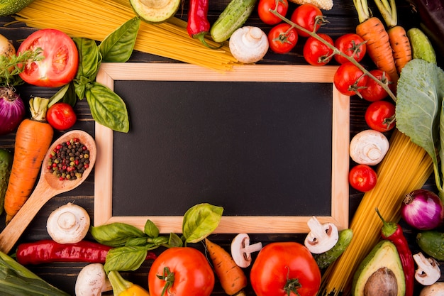 Top view assortment of different vegetables with blackboard