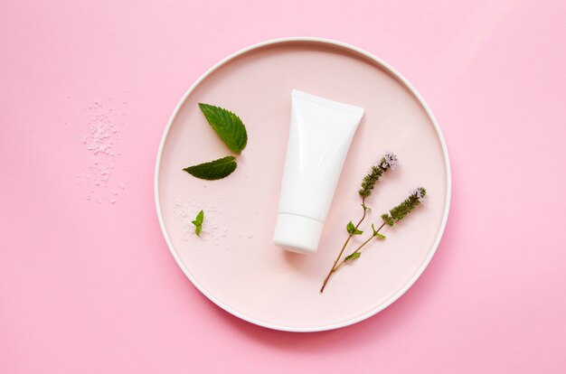 Top view assortment with cream bottle and leaves