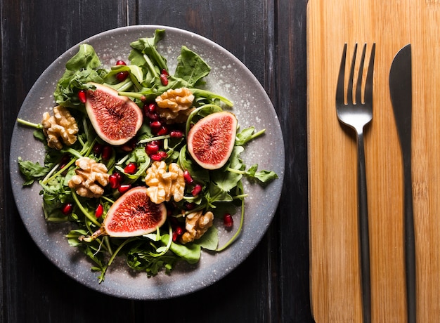 Top view of autumn fig salad on plate and cutlery