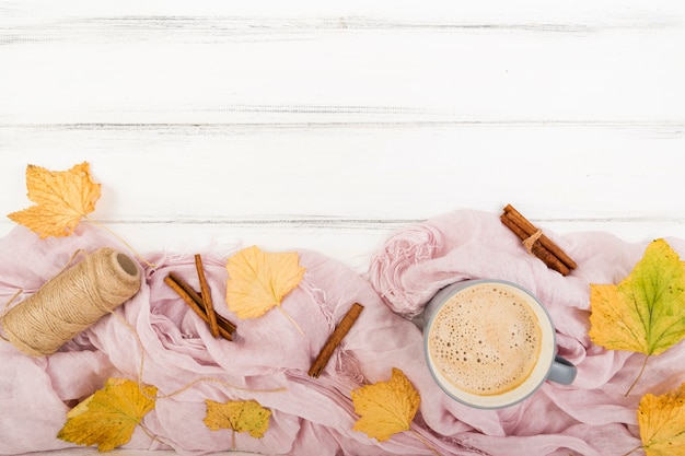 Top view autumn leaves surrounded by coffee