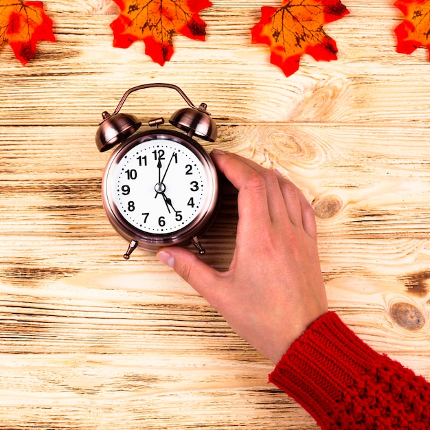 Free photo top view autumn leaves with clock