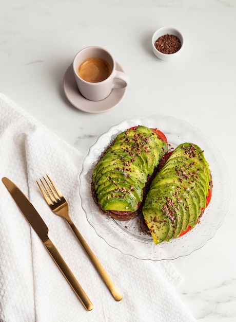 Free photo top view of avocado toast on plate with cutlery and coffee