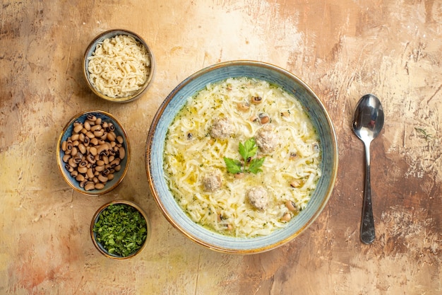 Free Photo top view azerbaijani erishte in bowl different stuffs in bowls a spoon on beige background