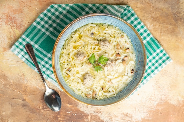 Top view azerbaijani erishte in bowl on kitchen towel a spoon on beige background