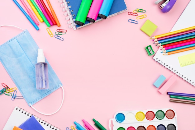 Top view of back to school essentials with pencils and medical mask