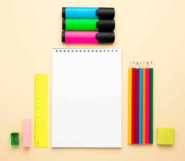 Top view of back to school stationery with colored pencils and notebook