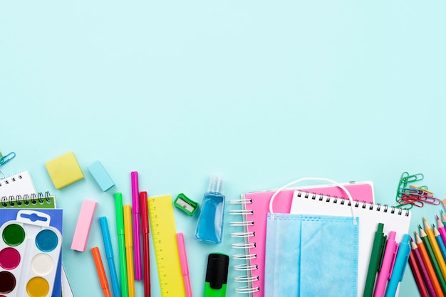 Top view of back to school stationery with medical mask and colorful pencils