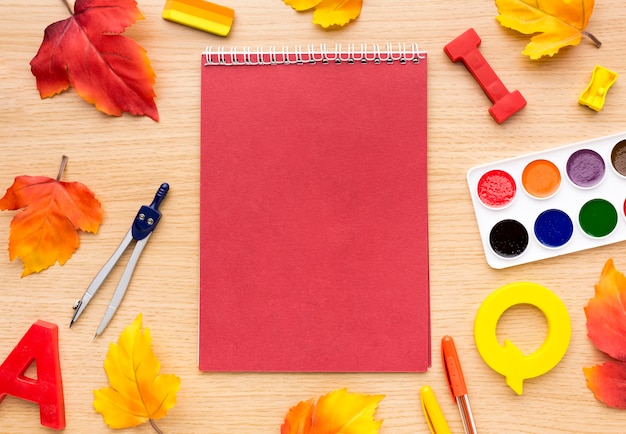 Free Photo top view of back to school supplies with notebook and leaves