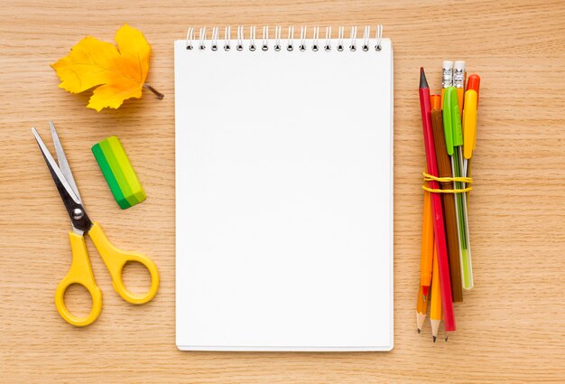 Top view of back to school supplies with notebook and scissors