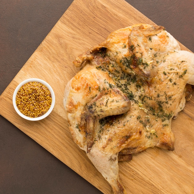 Free photo top view baked chicken on cutting board with dijon mustard