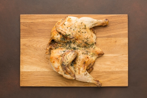 Free Photo top view baked chicken on cutting board