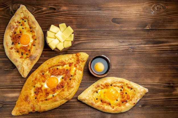 Top view baked egg breads fresh off the oven on brown wooden desk dough bread bun breakfast