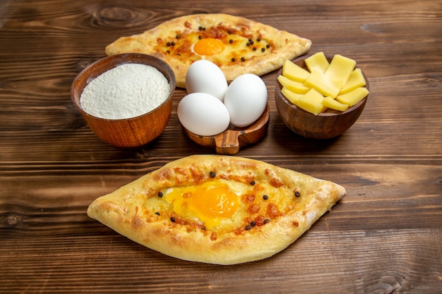 Top view baked egg breads fresh off the oven on the brown wooden desk dough egg bun breakfast bread