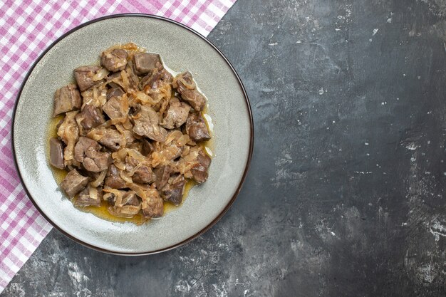 Top view baked liver with onion on grey round plate