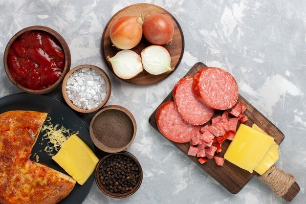 Top view baked pizza with different seasonings on white