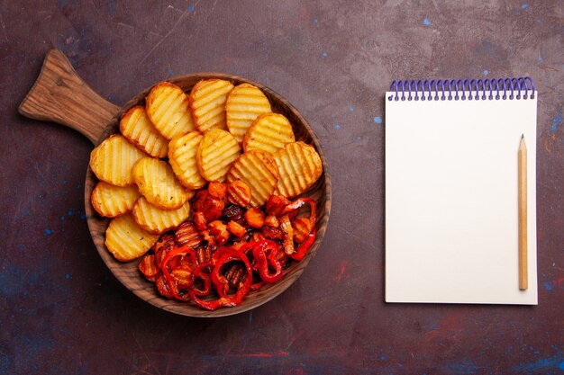 Top view baked potatoes with cooked vegetables inside plate on a dark space