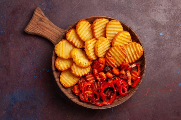 Top view baked potatoes with cooked vegetables inside plate on dark space