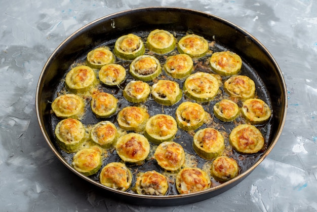 Free Photo a top view baked squash rings inside big black pan salted and tasty on the light desk vegetable meal food cooked