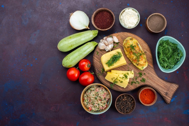 Free Photo top view baked squashes with greens cheese seasonings meat and fresh vegetables on the dark desk.