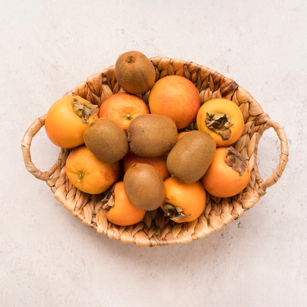 Free photo top view basket with exotic fruits on the table