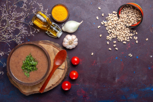 Free photo top view bean soup delicious cooked soup with olive oil on the dark surface soup bean color spicy meal