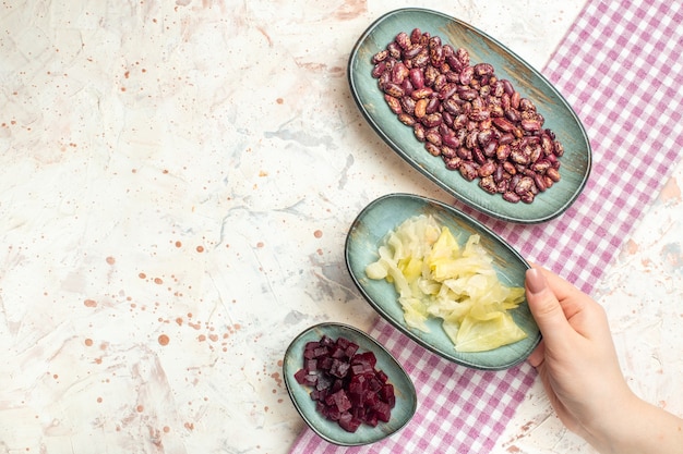 Free photo top view beans pickled cabbage cut beet on oval plates