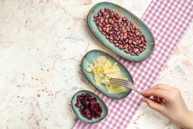 Top view beans pickled cabbage cut beet on oval plates