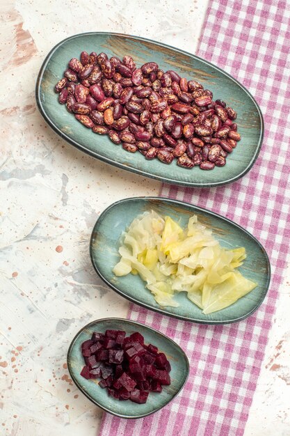 Top view beans pickled cabbage cut beet on oval plates