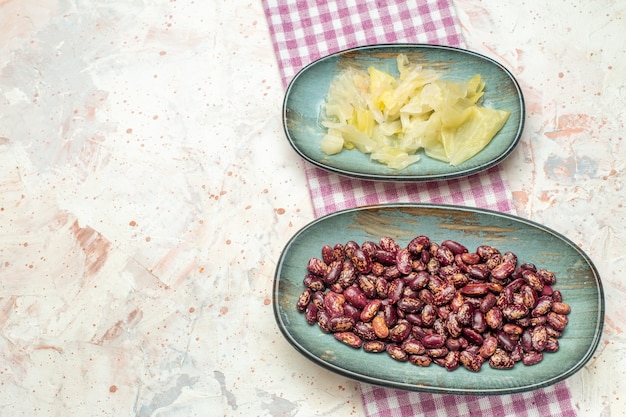 Free photo top view beans and pickled cabbbage on oval plates