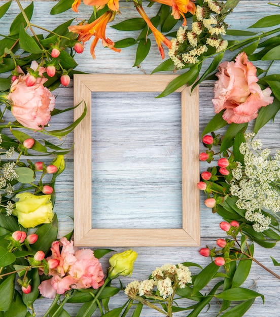 Free photo top view of beautiful and colorful flowers with leaves on grey wood with copy space