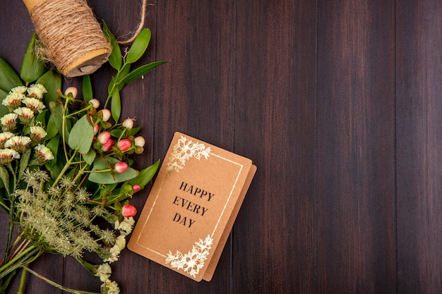 Top view of beautiful and colorful flowers with leaves on wood with copy space