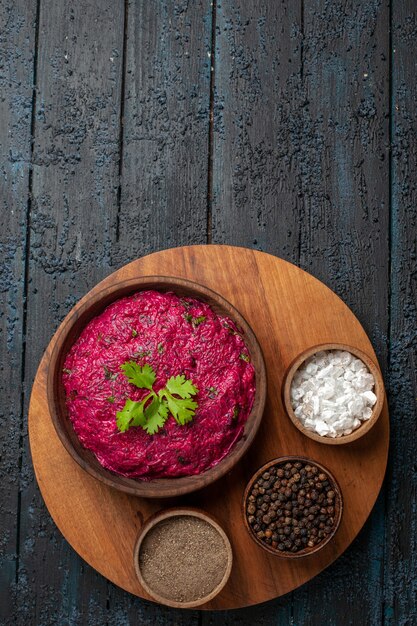 Top view beet salad with seasonings on dark desk