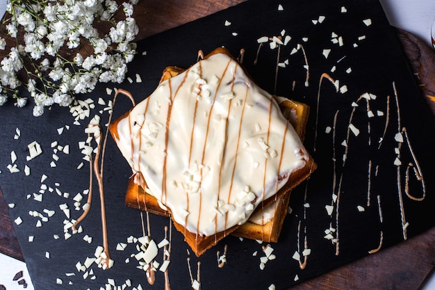 Top view of belgian waffle with white chocolate on the table