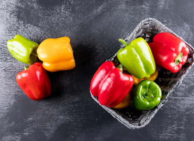 Free photo top view bell pepper in basket on black stone  horizontal