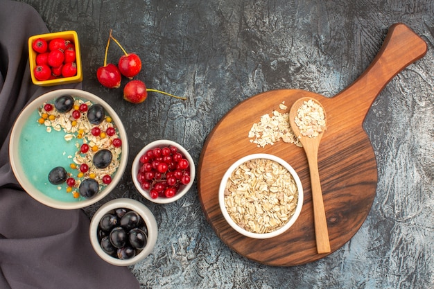 Top view berries colorful berries pomegranate seeds on the tablecloth oatmeal on the board