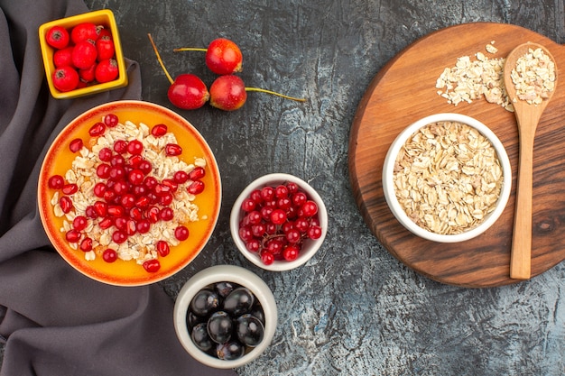 Top view berries oatmeal seeds of pomegranate berries on the tablecloth oatmeal on the board