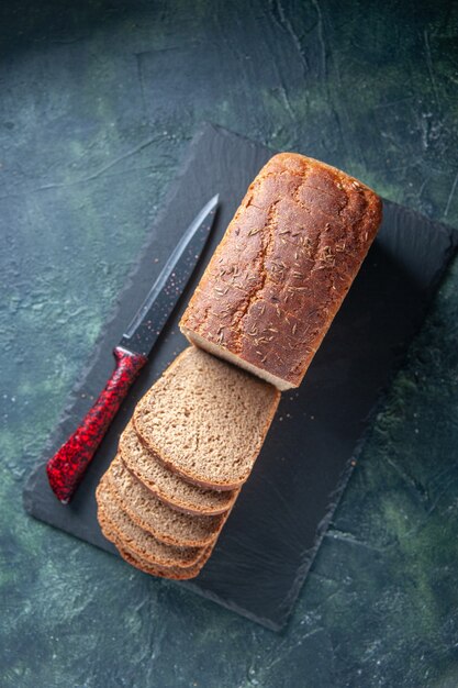 Free Photo top view of black bread slices knife on dark color board on blue distressed background