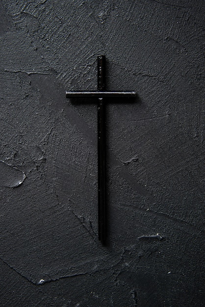 Top view of black cross on dark wall