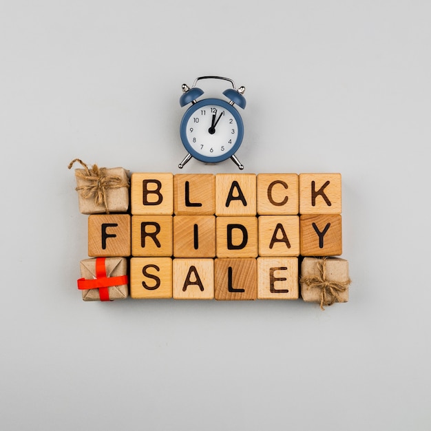 Free photo top view of black friday cubes and clock on plain background