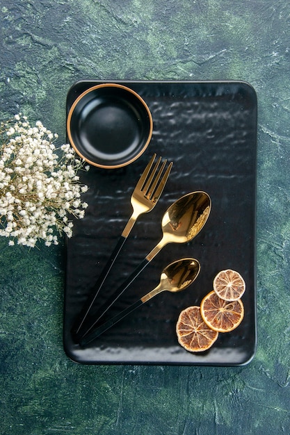 Free photo top view black plate with golden cutlery on dark surface cutlery color meal silver restaurant food tray service dinner