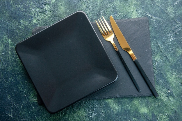 Free Photo top view black square plate with golden fork and knife on dark background color food restaurant cutlery dinner kitchen