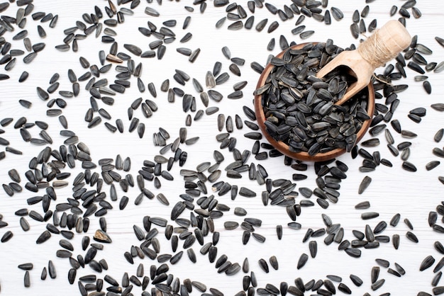 A top view black sunflower seeds fresh and tasty all over the white background grain sunflower seed snack oil