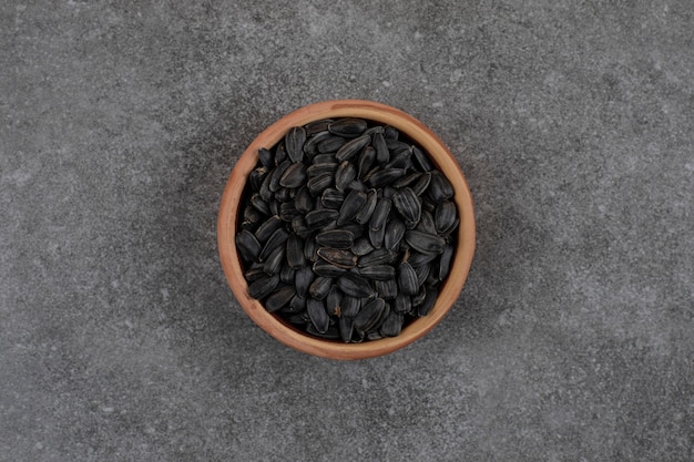 Top view of black sunflower seeds on grey surface