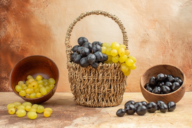 Free Photo top view of black and yellow fresh grapes fallen from small pots and in a basket